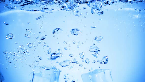 Ice Cubes Dropped Into Water with Air Bubbles