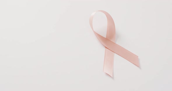 Video of peach pink uterine cancer ribbon on white background