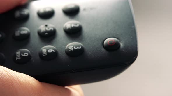 A Woman Turns a TV On/off with a Remote Control - Closeup