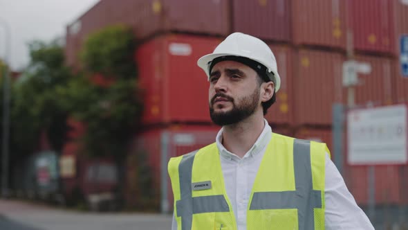 Focused Man in Helmet Walking on Warehouse Harbor