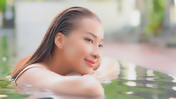 Young asian woman enjoy around outdoor swimming pool for leisure