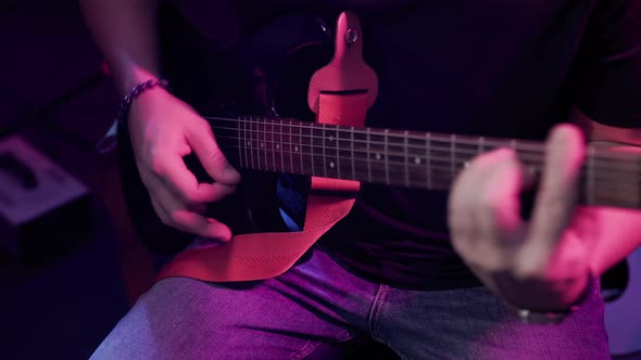 Close up hand playing guitar. Young musician playing guitar