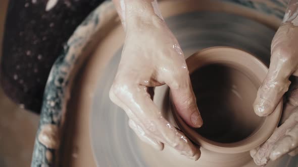 Man Potter Working on Potters Wheel Making Ceramic Pot From Clay in Pottery Workshop