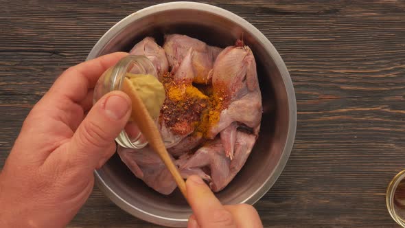 Top View of Raw Quails Marinated in a Bowl with Mustard and Spices