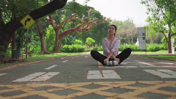 Asian sports women warming up before exercising in the park