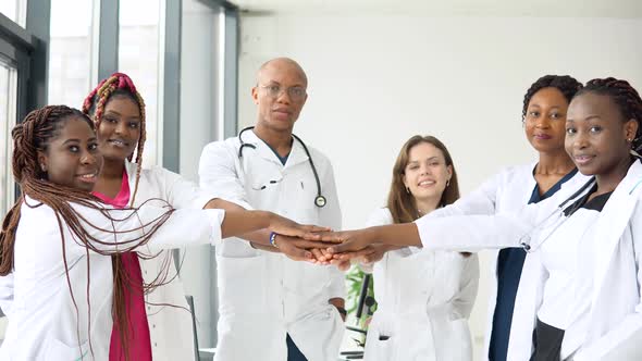 A Team of Doctors Including Women and Men of Different Nationalities Make a Gesture of Unity