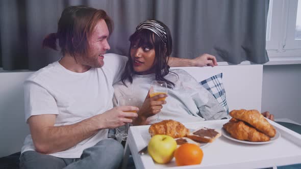 Young Happy Multiracial Couple Having Breakfast in the Bed