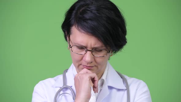 Serious Woman Doctor with Short Hair Thinking While Looking Down