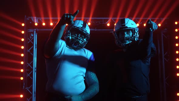 Two American Football Players in Sports Helmets and Uniform on Playing Stadium