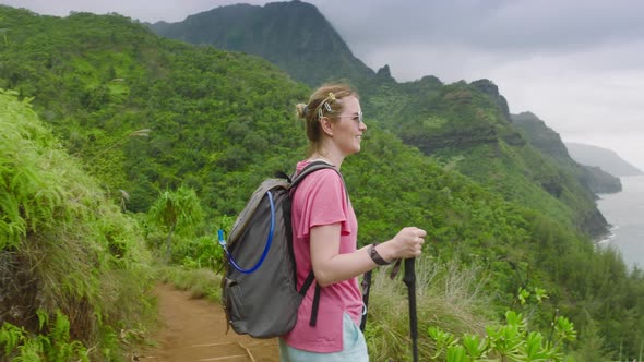 Slow Motion Woman Hiking By Green Rainforest Mountain Napali Coast Background
