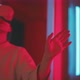 Young woman experiencing virtual reality with hands up in red neon lights - VideoHive Item for Sale