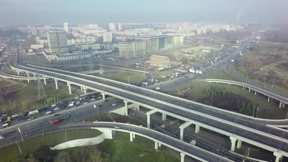 An Aerial View of a Road Interchange Against the Misty Urban View