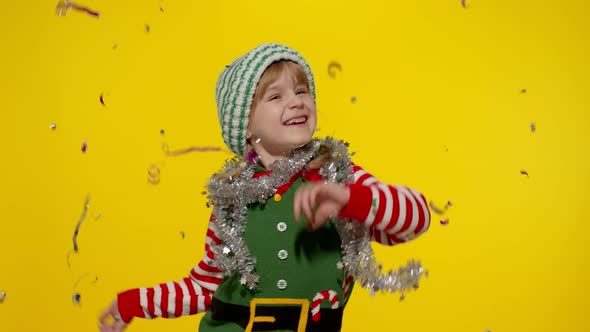 Kid Child Teenager Girl in Christmas Elf Santa Helper Costume Having Fun Rejoices Over Confetti Rain