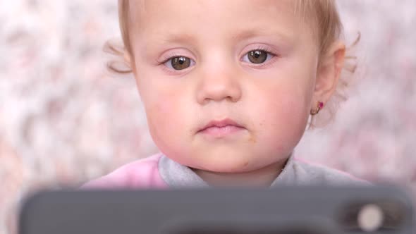 Little Beautiful Girl Watching a Cartoon From the Phone