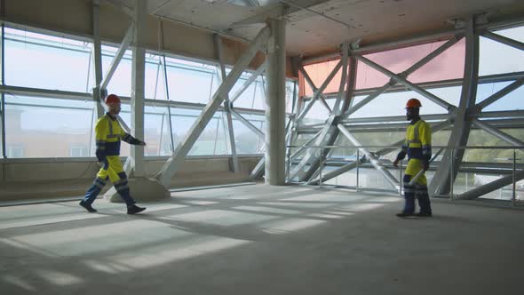 Side View of Diverse Foreman and Engineer Shaking Hands While Standing on Construction Site