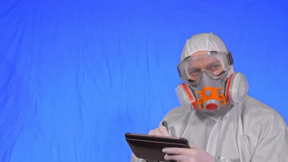 Scientist Virologist in Respirator Makes Write in an Tablet Computer with Stylus