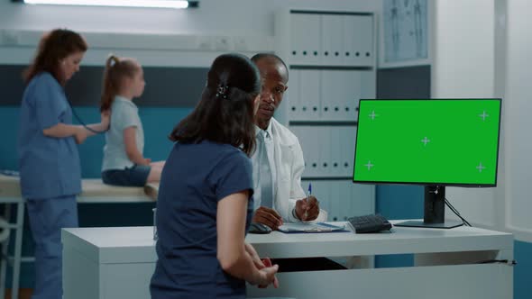 African American Man and Mother Looking at Green Screen on Monitor