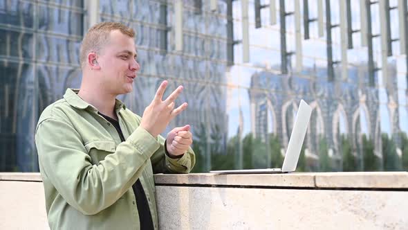 Caucasian Man Communicates in Sign Language Via Video Link on Laptop