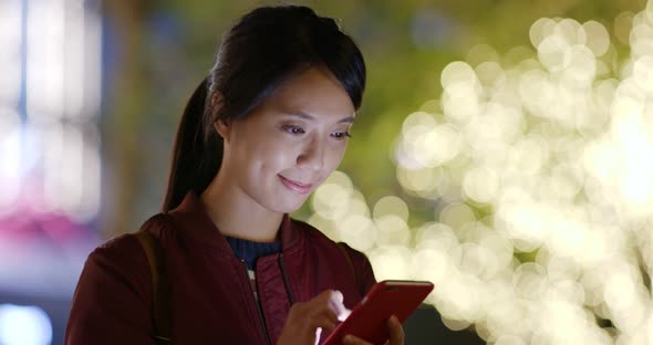 Woman use of mobile phone at night with city bokeh background