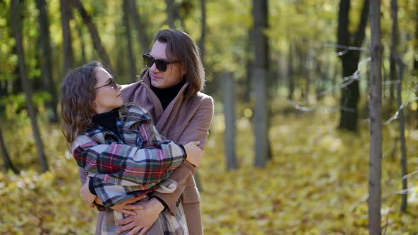 Happy Spouses are Spending Weekend Together Walking in Park in Autumn Day