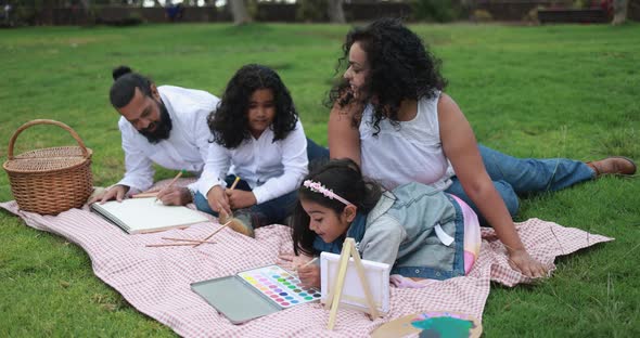 Indian parents having fun at city park painting with their children