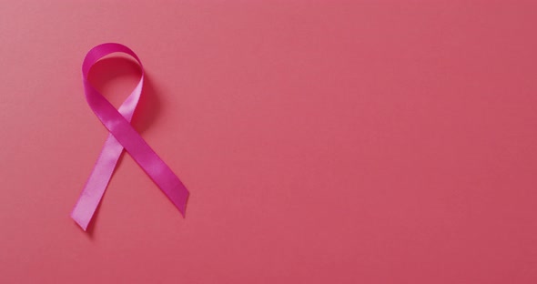 Video of pink breast cancer ribbon on dark pink background