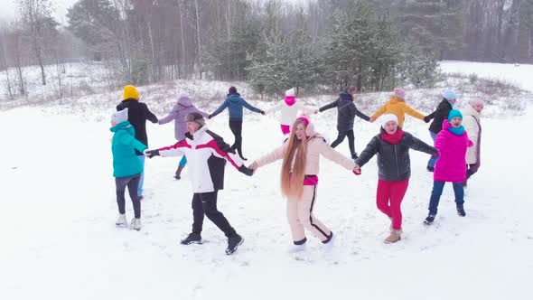 Top view group men and women in winter snowy forest in round dance