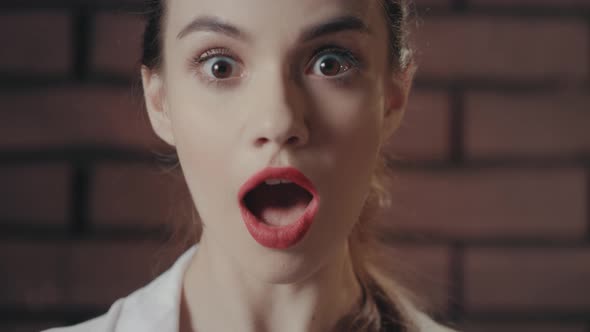 Surprised Woman Opened Mouth From Amazement on Brick Wall Background