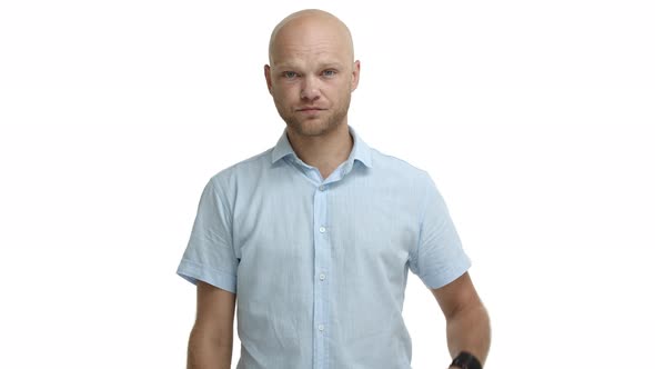 Middleaged Bald Man with Beard Wearing Casual Shirt Looking Annoyed and Tired Making Facepalm and