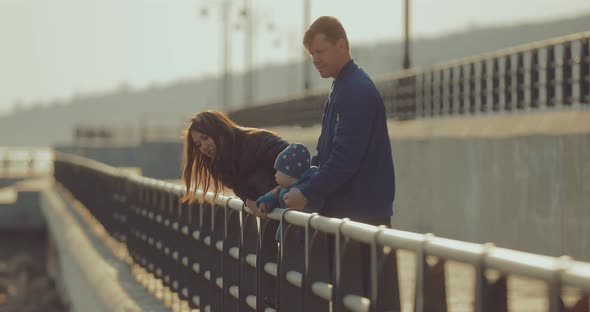 International Family Walks Along the Pier with a Young Son