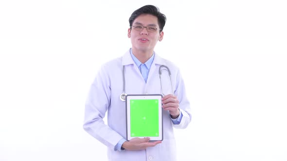 Happy Young Asian Man Doctor Talking While Showing Digital Tablet