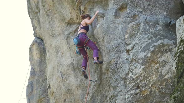 Young Woman Climber Falling Down After Failed Attemp to Climb Steep Wall of Rocky Mountain