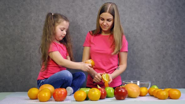 Mother and child daughter preparing fruit