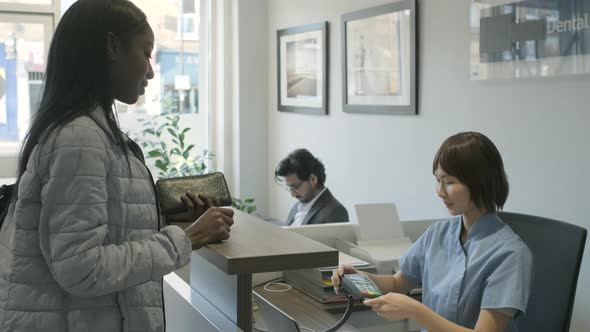 Patient using card reader to pay at front desk