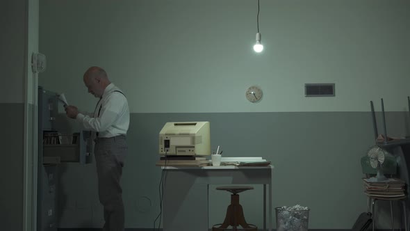 Businessman searching for files in the filing cabinet