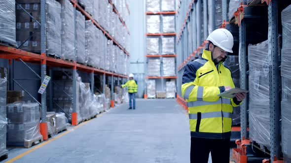 Worker male warehouse worker engineer man in a helmet working on the construction site