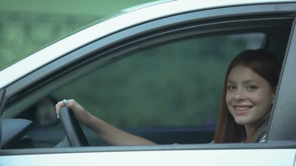 Cheerful Girl Showing Automobile Key Sitting on Driver Seat, Test-Drive, Gift