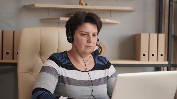 Old Woman Wearing Headset, Holding Video Call Support Services with Customer.