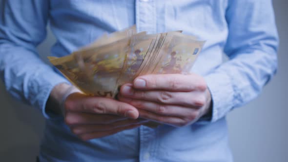 Man counting 50 euro, paper money bills and offers them to someone