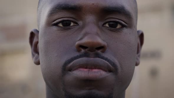 Close Up Portrait of Young African Man Looking at Camera with Serious Face