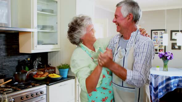 Romantic senior couple dancing in kitchen 4k