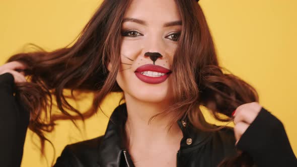 Pretty Young Woman in Cat Woman Cstume Preparing in an Orange Studio