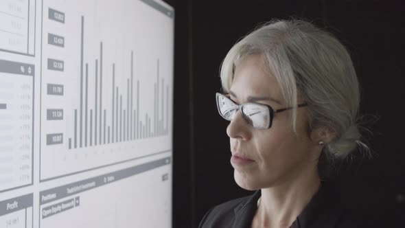 Serious Female Financial Advisor Analyzing Trading Charts