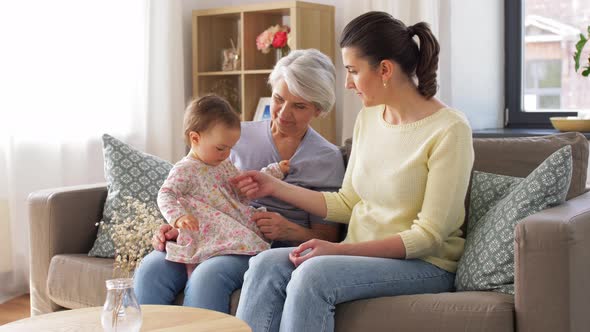 Mother, Daughter and Grandmother on Sofa at Home