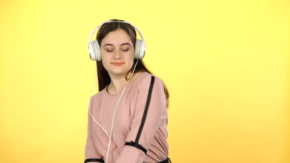 Young Girl Listening To Music in Big White Headphones