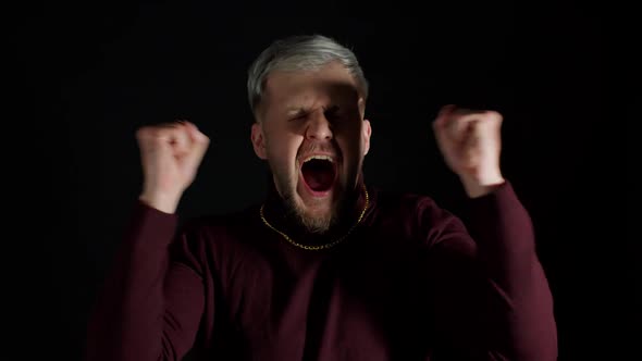 Overjoyed Young Man Wins Competition Achieves Goal and Makes Triumph Gesture Says Yes Shows Fist