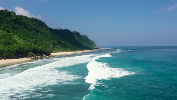 beautiful turquoise ocean waves on Bali coastline in Uluwatu on sunny day, aerial