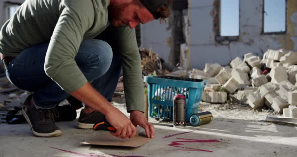 Graffiti artist cutting cardboard with cutter 4k