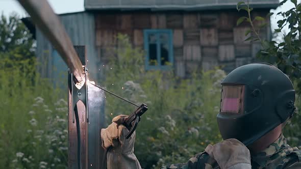 Slow Motion Man Welds Fence and Looks at Finished Work