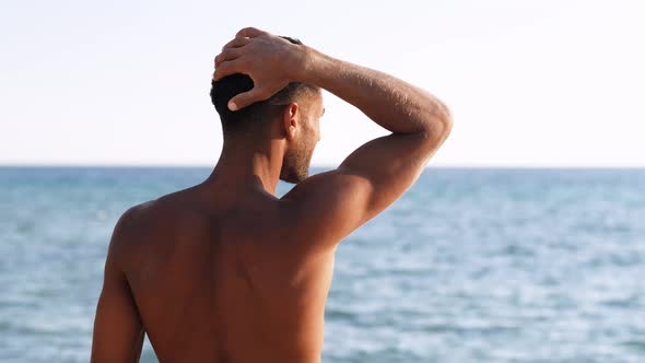 Backside View of Relaxing Young African Man Traveler on the Beach Handsome and Confident Topless Guy